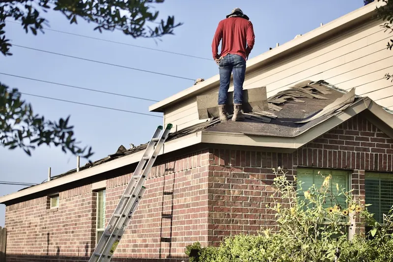 Professional roofer working on a residential roof in Triangle